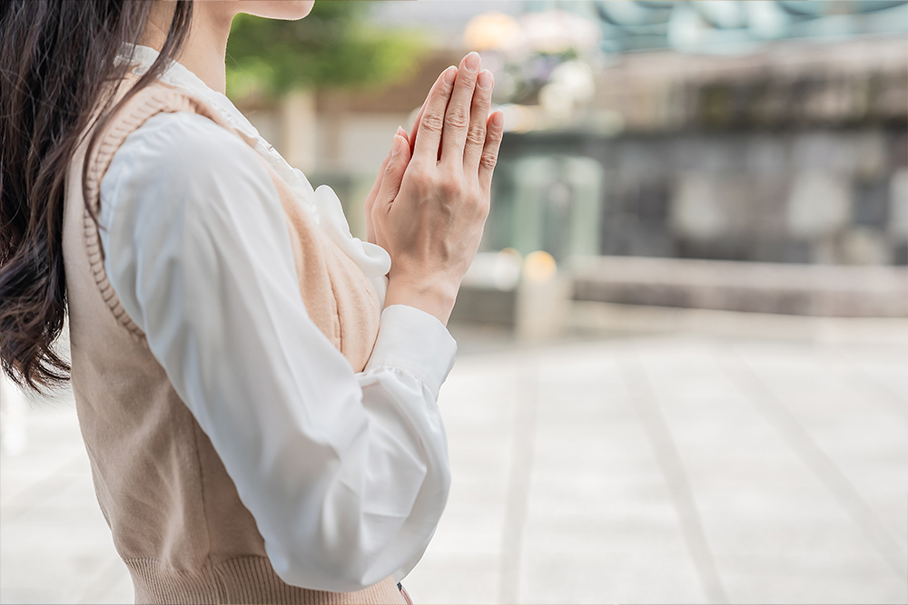 一位女性家屬在明亮、安心的懷恩生命紀念館追思空間中莊嚴祭拜。