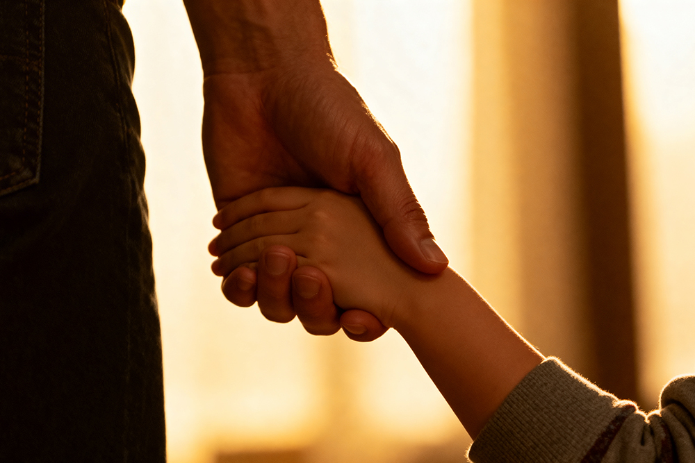 大人牽著小孩的手在生命紀念館溫馨追思，象徵家族情感與祭祀文化的圓滿傳承